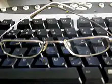 A pair of glasses sitting on a computer keyboard.