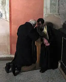 A penitent confessing his sins in a Catholic church in Lviv, Ukraine.