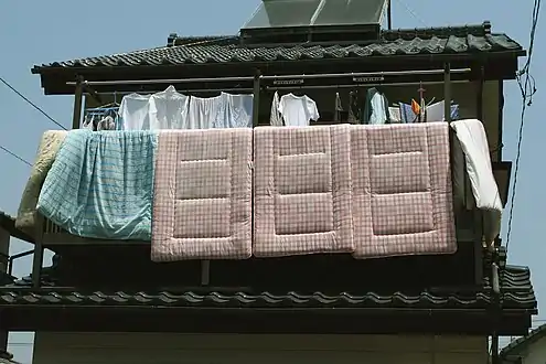 Futons hung out to air on a balcony.