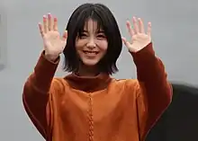 Minami Hamabe facing camera and waving with both hands