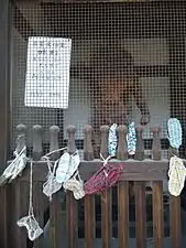 straw- and rag-woven sandals hung as offerings