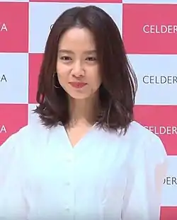 Song Ji-hyo in white shirt and smiling for the camera in 2019