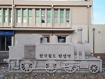 An outdoor plaque of a steam engine commemorating the birth of Korean rail