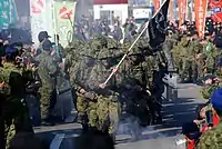 Marching at the end of the final exercise while other soldiers cheer them on.