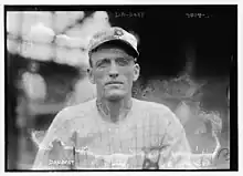 A man in a light baseball uniform.