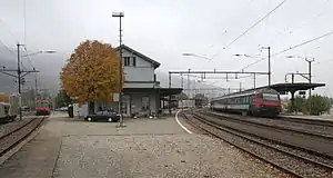 Two-story building with gabled roof between two sets of railway lines