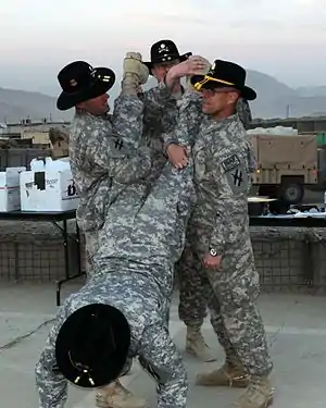 A trooper from the 1st Squadron, 108th Cavalry receives his golden spurs as part of the 'Roughriders' New Year's celebration event at FOB Torkham, Afghanistan. Golden spurs are awarded to Cavalry Troopers for service with a Cavalry unit in a combat zone.