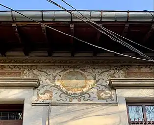 Beaux Arts fresco with cartouches and foliage spirals on the upper part of the facade of Strada Occidentului no. 11, Bucharest, painter: C. Cora, architect: Cesare Fantoli, 1910