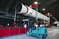 A forklift is seen working a stand holding an SRMU rocket.