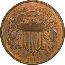 A bronze coin with a shield in the center, dated 1865.