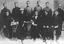 Photograph of members of the Union of Poor Peasants, some seated and others standing, all wearing dark clothing