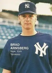 A man in a navy blue baseball jersey and cap