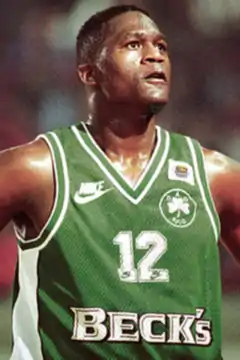 A man, with a Panathinaikos jersey in a game looking up.