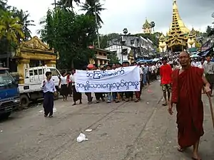 Image 6Protesters in Yangon with a banner that reads non-violence: national movement in Burmese, in the background is Shwedagon Pagoda. (from History of Myanmar)