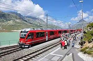 Red train parked at island platform