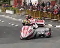 2013 Isle of Man TT Sidecar Race 1 — Lap 3 Tim Reeves/Dan Sayle (3) & Dave Molyneux/Patrick Farrance (1) Parliament Square, Ramsey 1 June 2013.