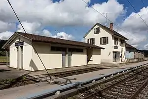 Three-story building with gabled roof and adjoining freight house