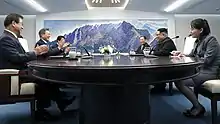 Kim, Moon, and others, around the conference table in the Peace House's room designated for meetings between heads of state, April 27, 2018