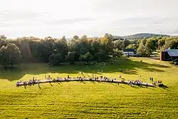 Diners sit at a single long table enjoying a four course family-style meal amongst farmers, winemakers, and strangers