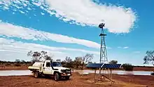 Old landcruiser next to windmill frame used for wireless internet