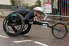 White man dressed in black in a black wheelchair