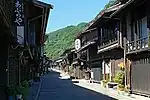 Small street lined by wooden two-storeyed houses.