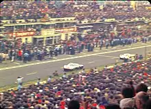 The GT40 of Ickx/Oliver passes the pits just ahead of the Porsche 908 of Herrmann/Larrousse