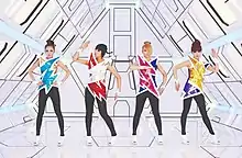 2NE1 striking a pose in front of a drawn set