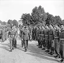 Soldiers ranked in review order, being inspected by commanding officer