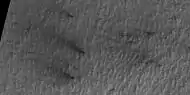 Close view of defrosting, as seen by HiRISE under HiWish program Gas and dark dust is probably being blown out of ground and then carried by winds toward the Northwest.