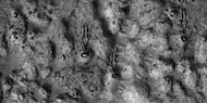 Close view of ejecta, as seen by HiRISE under HiWish program  Note:  Arrows show examples of boulders sitting in pits.