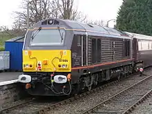 Yellow-and-grey locomotive pulling a passenger train