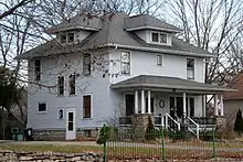 Image 5A wood-frame American Foursquare house in Minnesota with dormer windows on each side and a large front porch