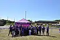 Images shows staff and volunteers celebrating outside a marquee.