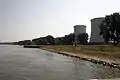 Biblis Nuclear Power Plant is on the Rhine river. On the right side two cooling towers from unit A. In the background a ship landing place where heavy components such as reactor vessels and steam generators were landed by ship.