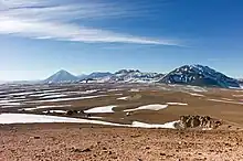 Mountain across a plateau, dwarfing a radio telescope in the foreground