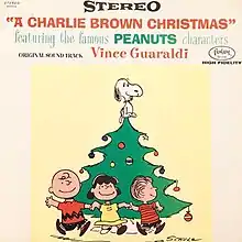 A drawing of some of the Peanuts gang running around a Christmas tree