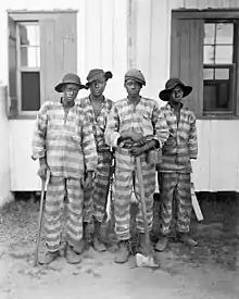 Many prisoners chained together standing together.