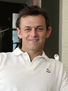 A man wearing the white collared T-shirt.