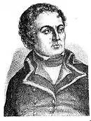 Black and white print of a curly-haired man with a small mouth. He wears a dark coat from a late 18th century military uniform.