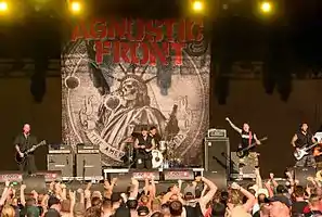 Band on stage in front of The American Dream Died poster