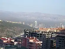 Photograph of haze from burning coal over apartment blocks