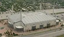 Aerial image of a rectangular building with towers pointing skyward in each corner of the building.