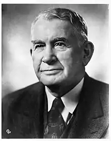 A black and white photo of a man in his fifties wearing a suit