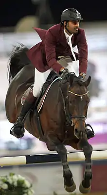 Front view of a horse and rider clearing an obstacle.