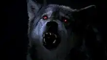 A dog with glowing red eyes barks menacingly.