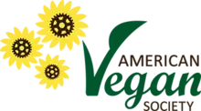 The words "AMERICAN Vegan SOCIETY" appear on the right of the logo, with "Vegan" in green. On the left side of the logo there are three yellow flowers with gears on the middle.