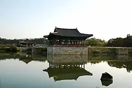 Pond lined by a wall and two pavilions