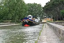 The hotel barge Anjodi crossing the Cesse River on the Canal du Midi.