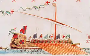 Colorful image of a Mediterranean-type galley with English and Tudor flags with its oars out and a figure standing in the stern